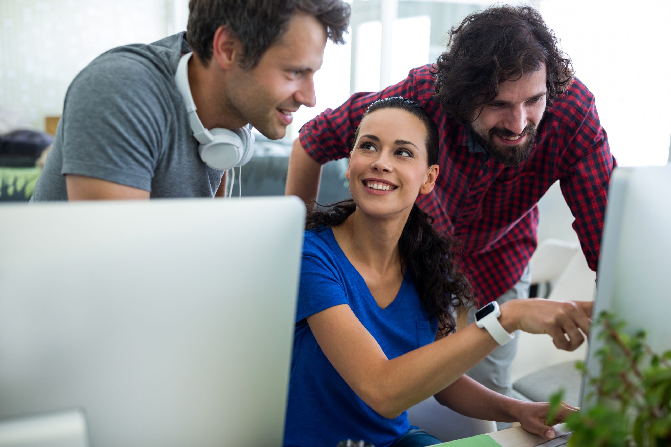 Group of graphic designers interacting over computer in office